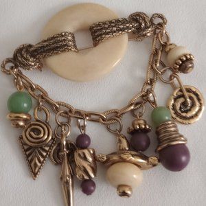 Gold tone pin brooch 3.5"wide 9 dangling charms Unsigned, good condition.